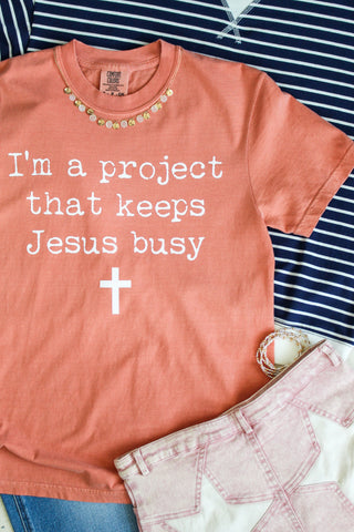 I’m A Project That Keeps Jesus Busy Graphic Tee • Peach
