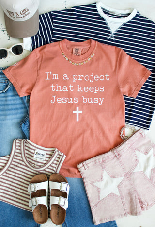 I’m A Project That Keeps Jesus Busy Graphic Tee • Peach