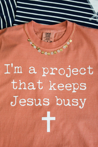 I’m A Project That Keeps Jesus Busy Graphic Tee • Peach
