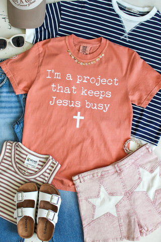 I’m A Project That Keeps Jesus Busy Graphic Tee • Peach