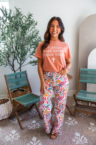 I’m A Project That Keeps Jesus Busy Graphic Tee • Peach